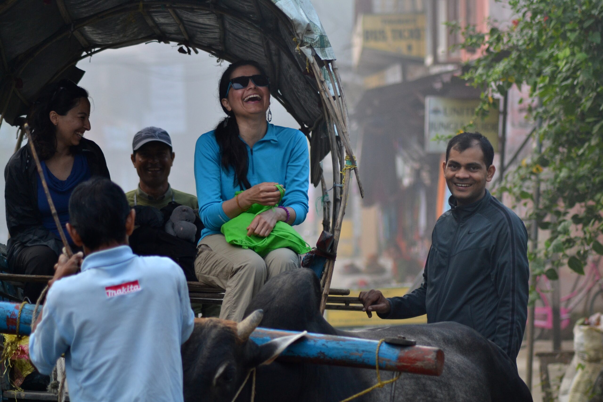 Happy tourists on traditional ox cart safari with local guide in Sauraha village near Rhino Lodge & Hotel, Chitwan National Park Nepal